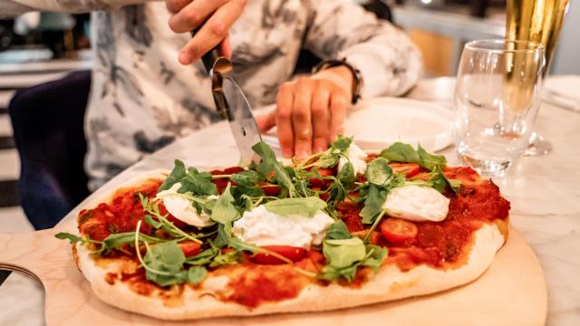 Jeune homme découpant une pizza au restaurant du Casino de Dieppe