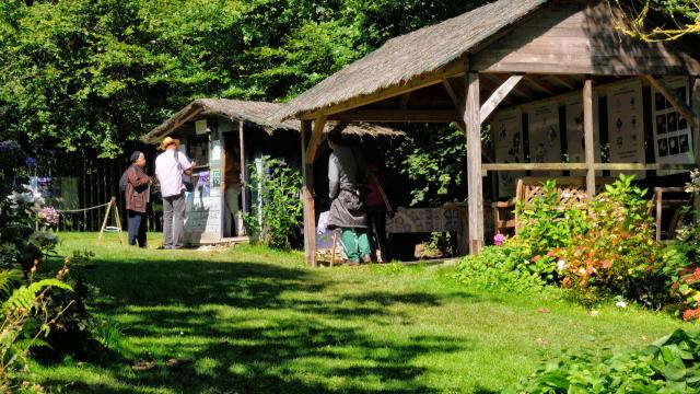 Cabane en bois de l'accueil du jardin. Préau en bois avec panneaux explicatifs