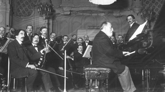 Camille Saint-Saëns au piano entouré de musiciens