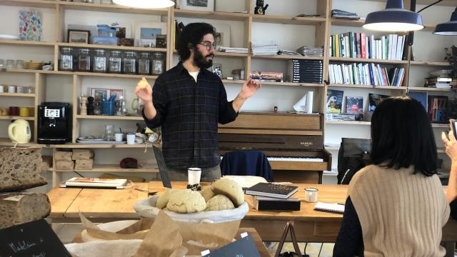 Un salarié de la boulangerie faisant visiter à une femme la boulangerie et explique la fabrication de ses produits.