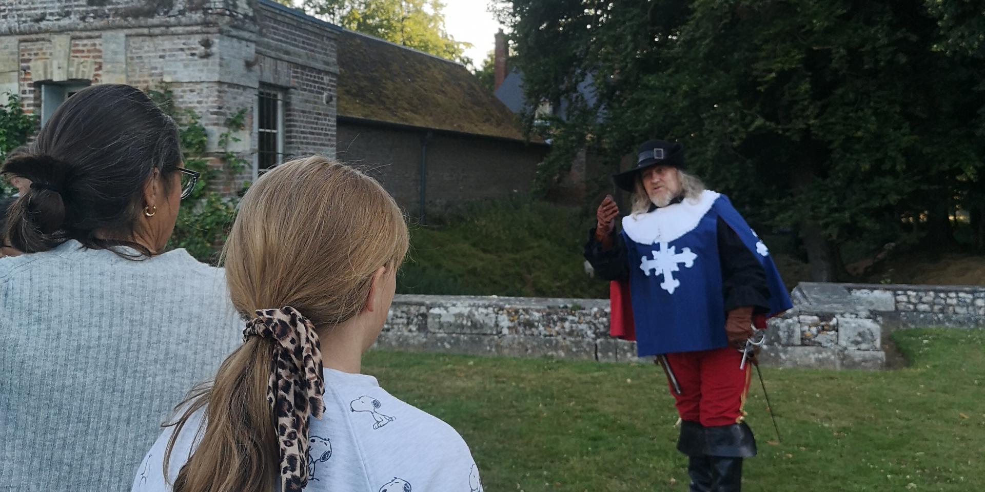 Un homme jouant un rôle dans le jeu Cleudo au Château de Mirosmenil, il joue devant une mère et sa fille