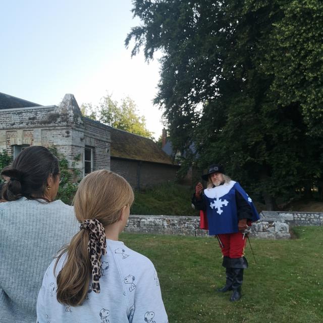 Un homme jouant un rôle dans le jeu Cleudo au Château de Mirosmenil, il joue devant une mère et sa fille