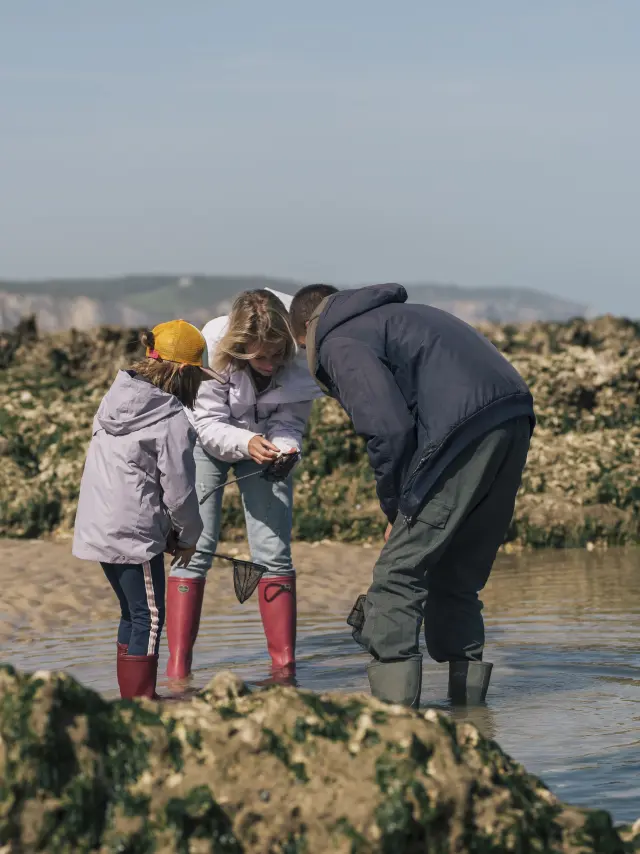 Une maman et sa famille, en compagnie d'un guide observent des animaux qu'ils viennent de pêcher