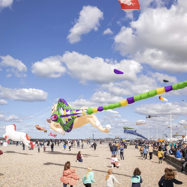 Des enfants courent sous un cerf-volant sur la plage de Dieppe