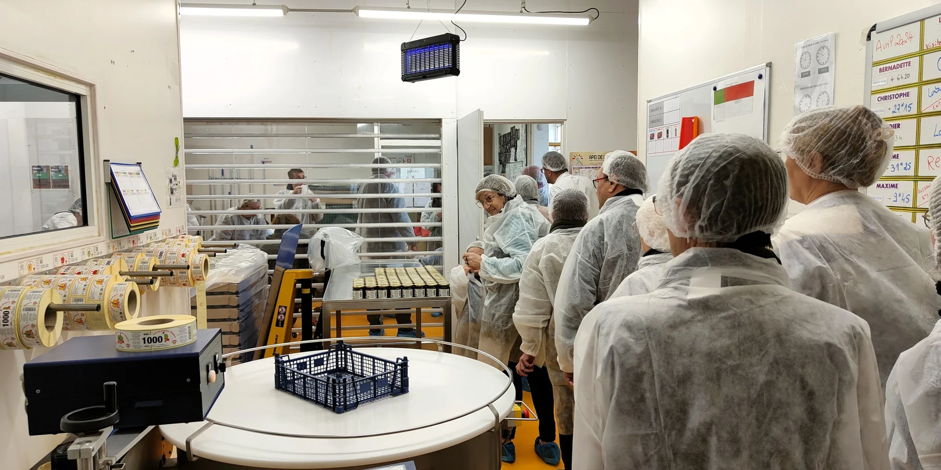 Un groupe de personnes équipées de charlottes et de vêtements de protection dans l'une des salles de conception du caramel de pommes dieppois