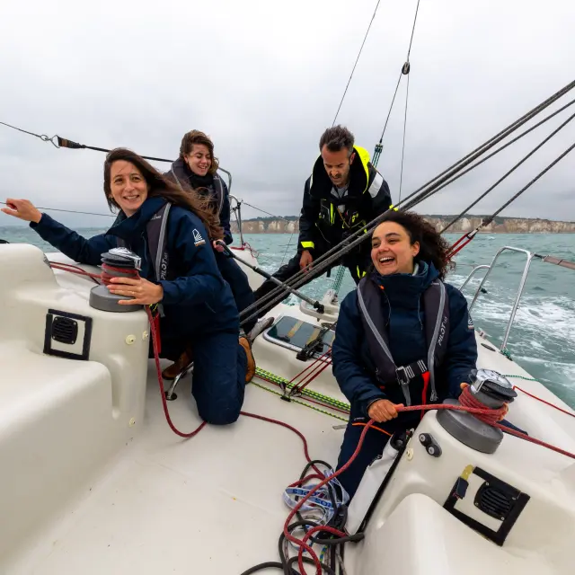 Un groupe en pleine sortie voile au large de Dieppe, profitant du vent et de la mer sous un ciel dégagé.
