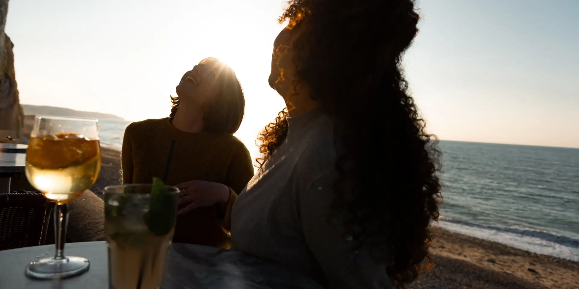 Petit groupe partageant un apéritif convivial sur les galets, face au soleil couchant à Dieppe.