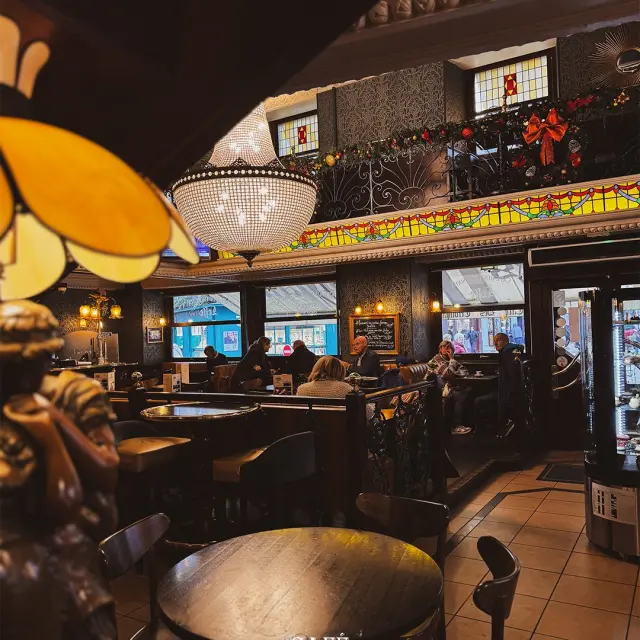 Groupe de personne installés sur les banquettes du Café Des Tribunaux