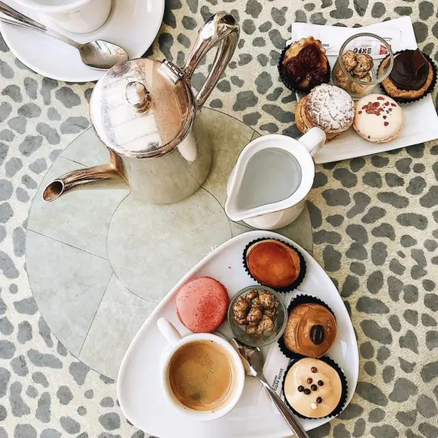 table avec service à thé avec des pâtisseries de toutes les couleurs