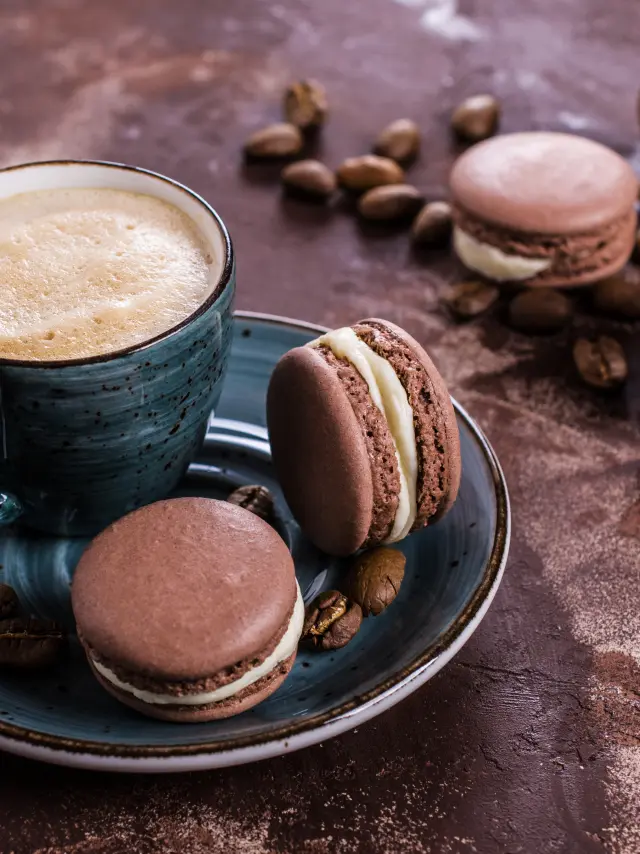 Une tasse de café avec des macarons