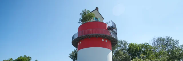 3 personnes à vélo qui passent devant la Villa Cheminee Oeoeuvre Du Parcours Estuaire Nantes Saint Nazaire Cadre Large