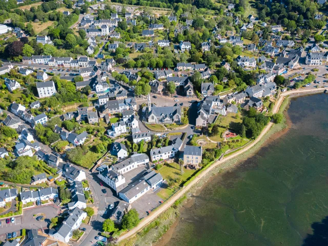 Luchtfoto van de kerk Notre Dame Izel Vor en de marktplaats La Forêt, inclusief huizen en een deel van de baai van La Forêt.