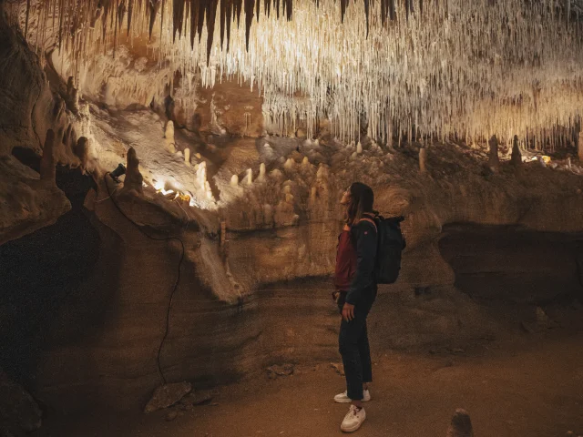 Woman under the concretions in the Cougnac caves