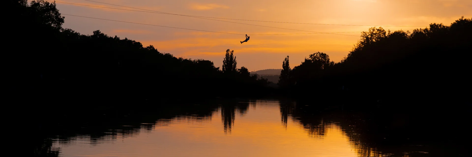 Tyrolienne at sunset on the Écoute s'il Pleut pond
