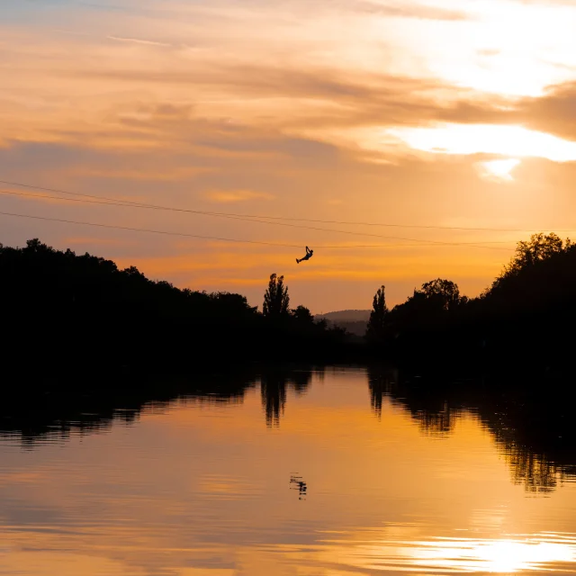 Tyrolienne at sunset on the Écoute s'il Pleut pond