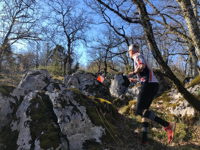 Sportif en train à la recherche de balises lors d'une course d'orientation dans les Causses du Quercy.