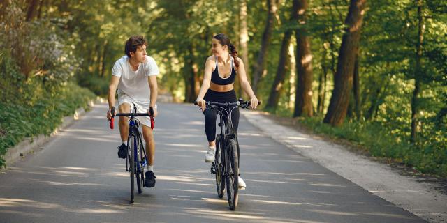 Velo Sports Couple Riding Bikes In Summer Forest
