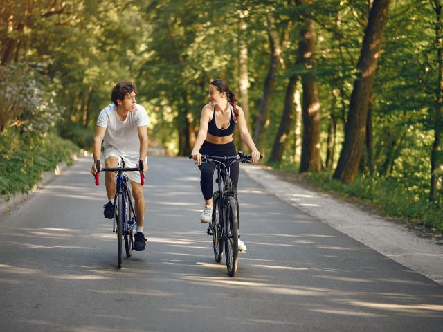 Velo Sports Pareja montando en bicicleta en el bosque de verano