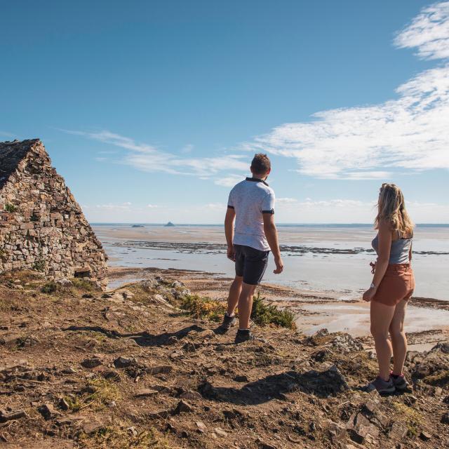 A couple observes Tombelaine and Mont saint-Michel from the Vauban hut on the Champeaux cliffs