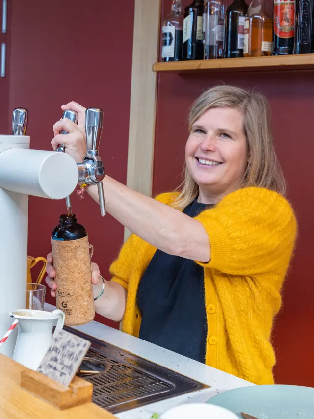 Une femme remplit une gourde dans un bar partenaire de Gourde Friendly