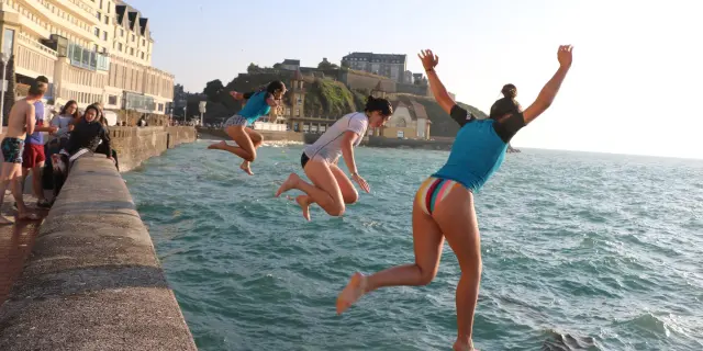 Des jeunes gens sautent dans la mer à marée haute depuis la promenade du Plat Gousset à Granville