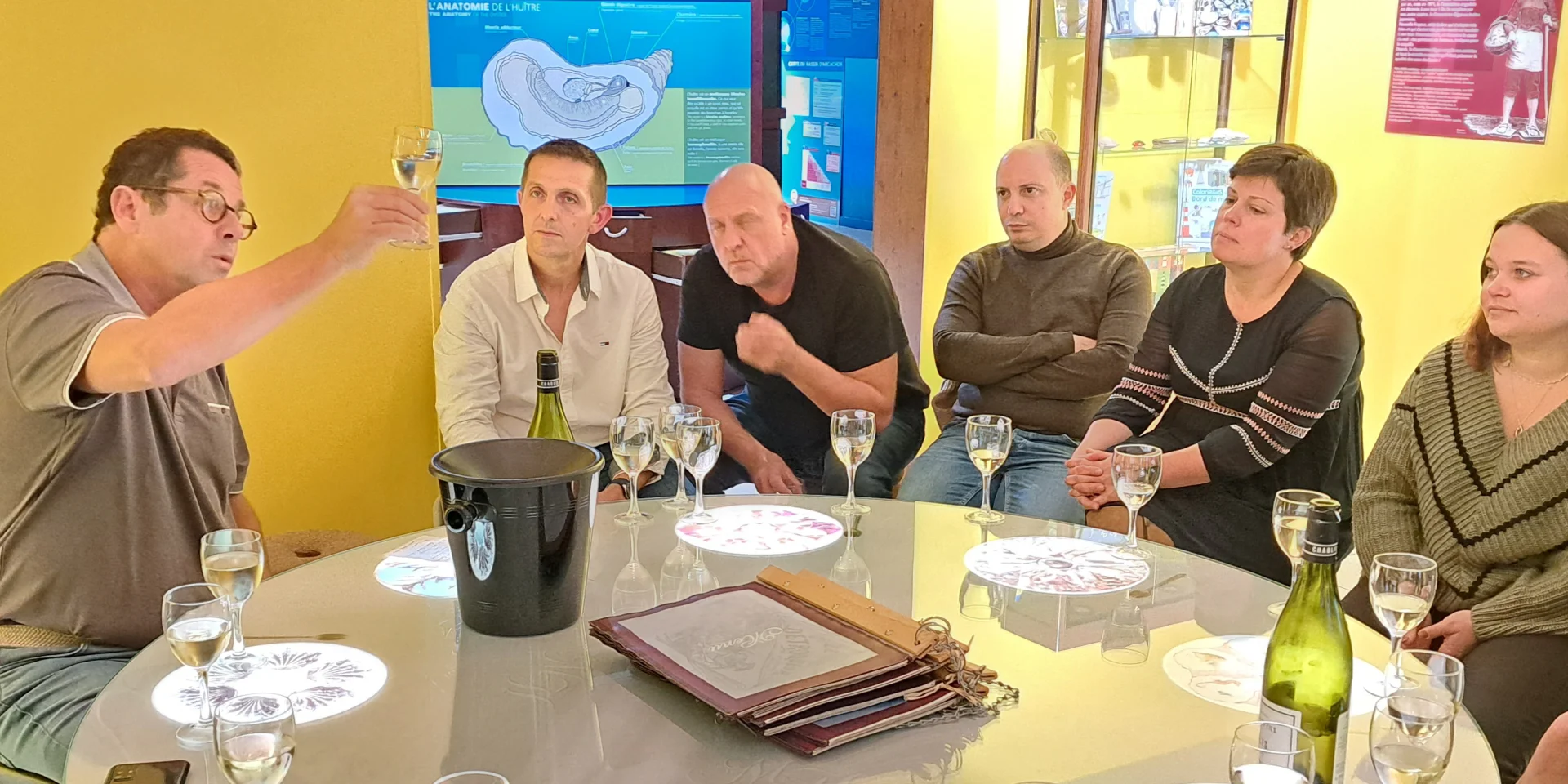 Groupe de personnes assis autour d'une table écoutant scrupuleusement le guide