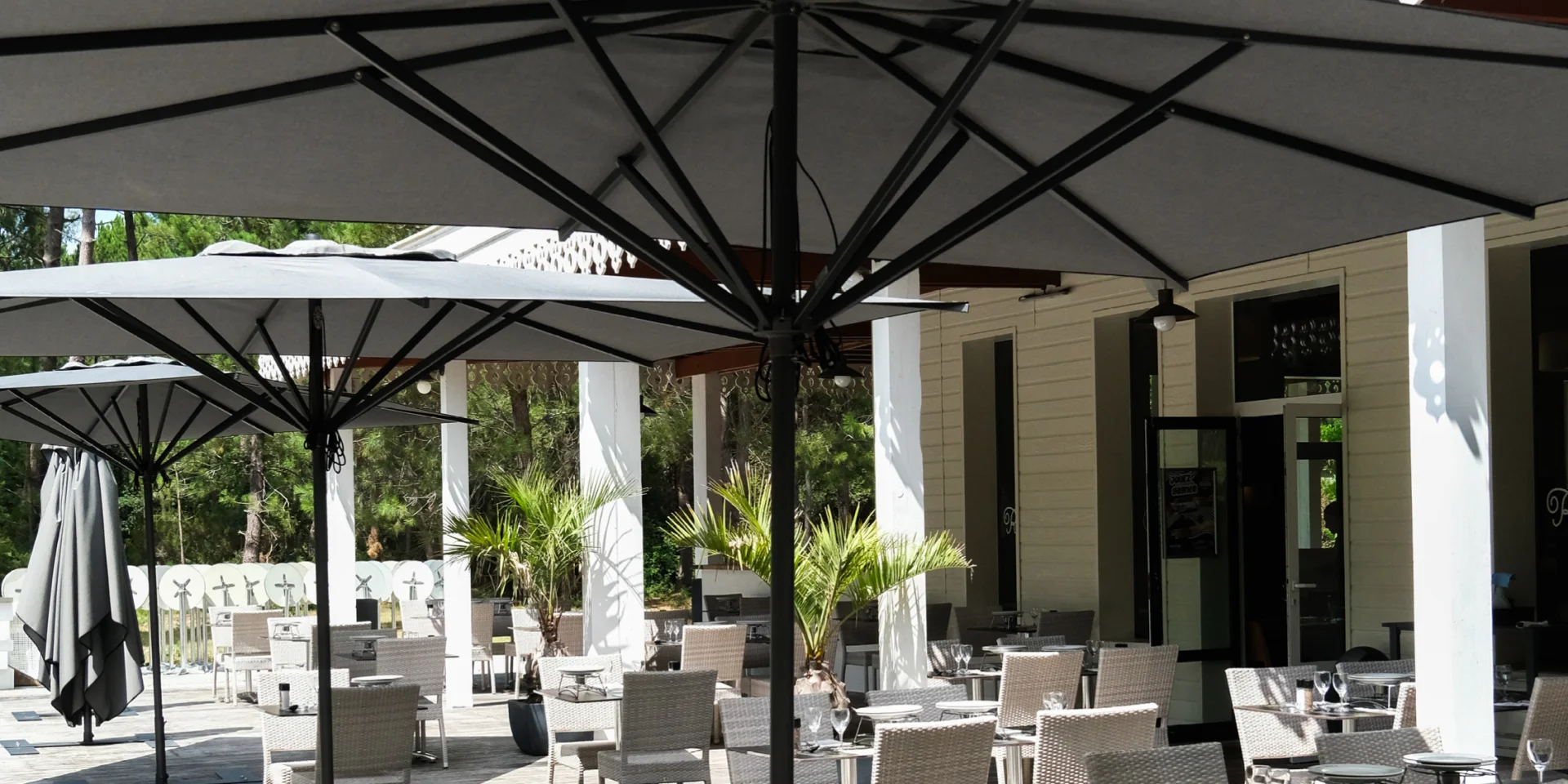 Terrasse extérieure d'un restaurant de Gujan-Mestras avec des tables dressées sous des parasols