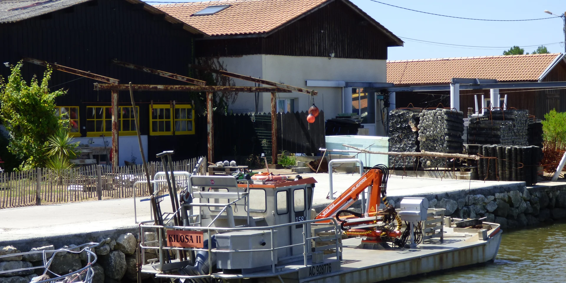 Plate ostréicole, bateau des ostréiculteurs pour ramasser les poches amarrée devant une exploitation ostréicole