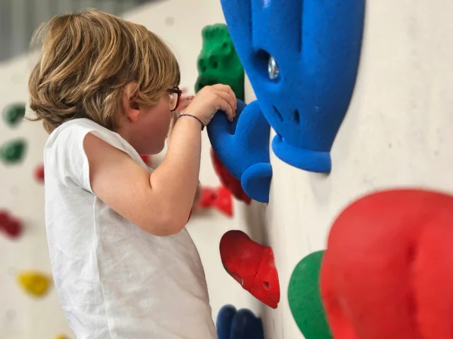Enfant de 6 ans grimpant à un mur d'escalade.