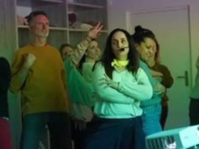 Groupe de personnes qui participent à une activité pour apprendre à lâcher prise par le chant.