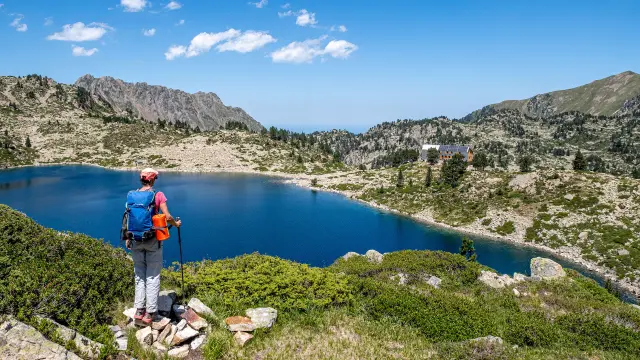 Une randonneuse devant le refuge de Campana du Cloutou et le lac du Campana.