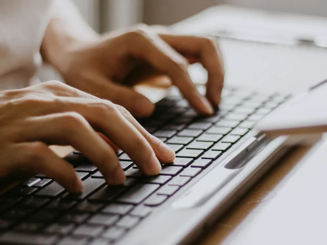Vue sur une personne travaillant sur un PC - outils digitaux