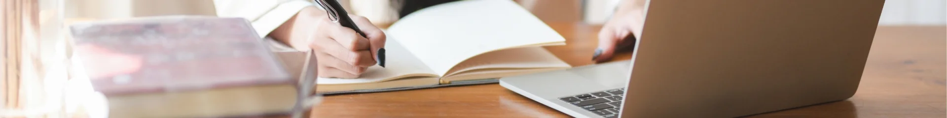 Une femme travaille sur un PC et prend des notes sur un carnet - Audit d'outils digitaux par Destination 70