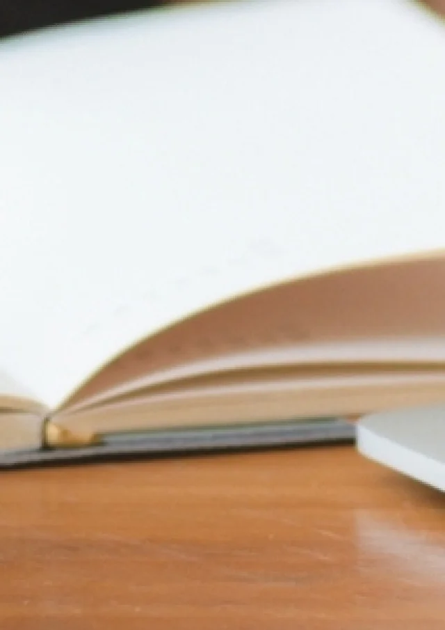 Une femme travaille sur un PC et prend des notes sur un carnet - Audit d'outils digitaux par Destination 70