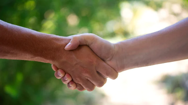 Deux personnes se serrent la main, scellant leur future collaboration - Accompagnement de projets touristiques par Destination 70