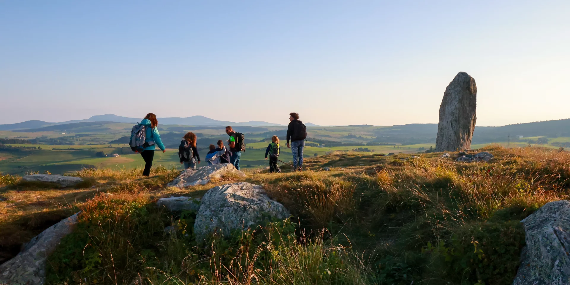 Family hike past the Pierre Levée near the Lizieux massif