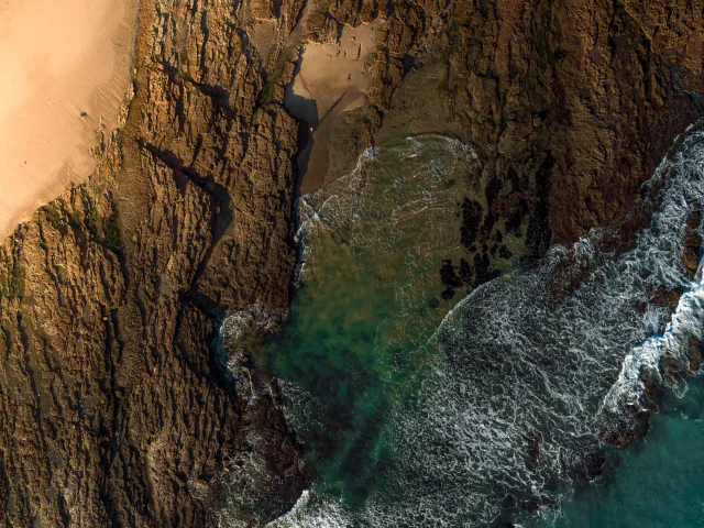 Vue aérienne d'une côte rocheuse avec des vagues.