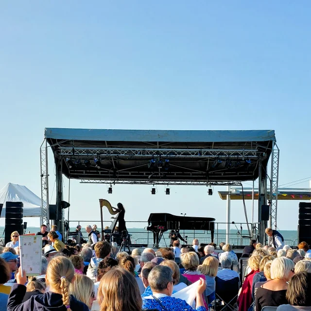 Concert en plein air à Rivedoux avec une foule rassemblée devant une scène.