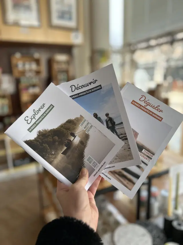Main tenant les 3 brochures de l'Office de tourisme