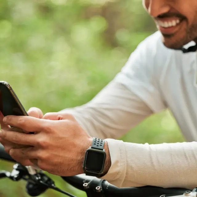 Cycliste avec un casque consultant une appli sur son téléphone