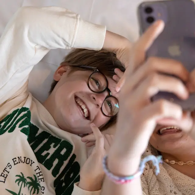 Enfants sur un lit qui rigolent