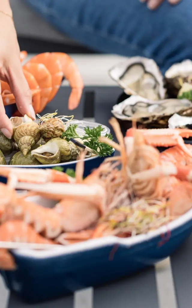 mainq ui bedient sich an den Langustinen und Austern, die auf einem Tisch präsentiert werden.