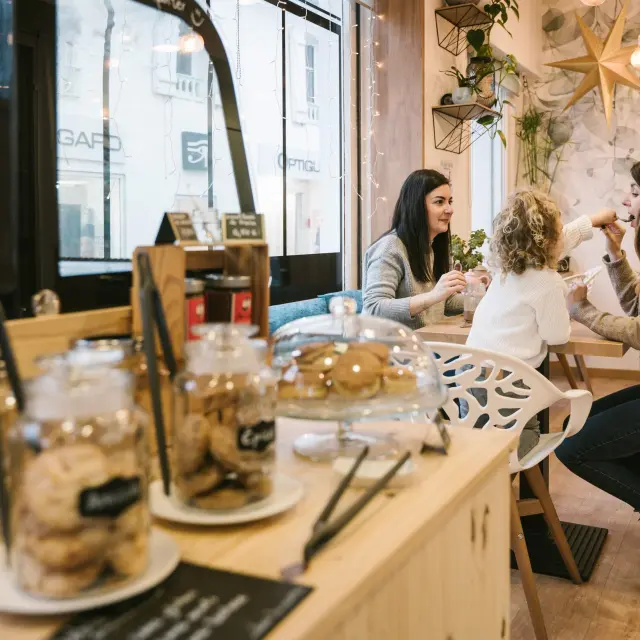 A group of friends and a little girl enjoying some sweet treats in a tea room