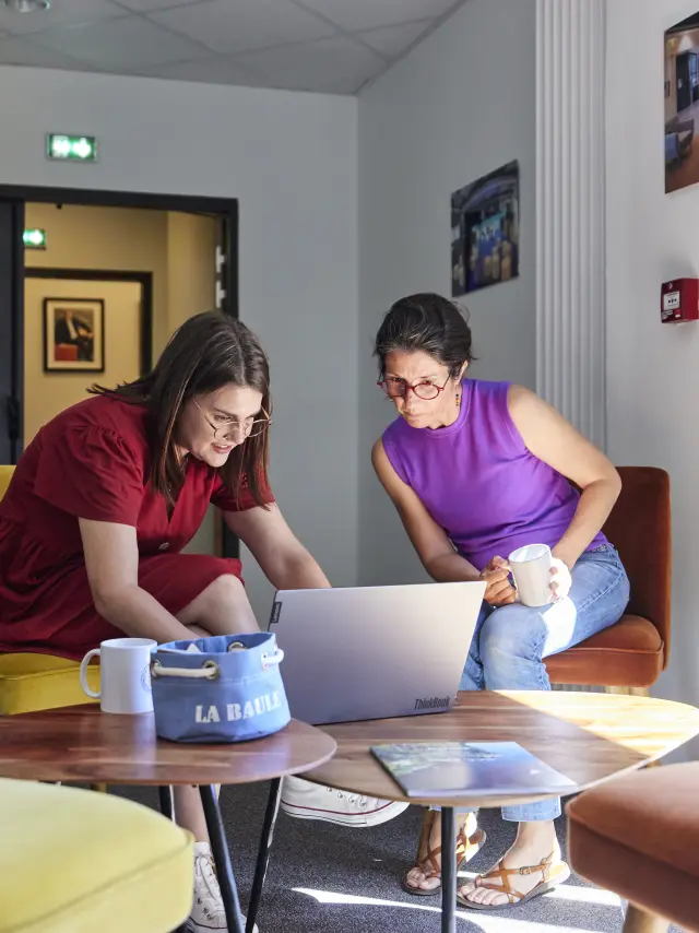 collègues qui échangent devant un ordinateur