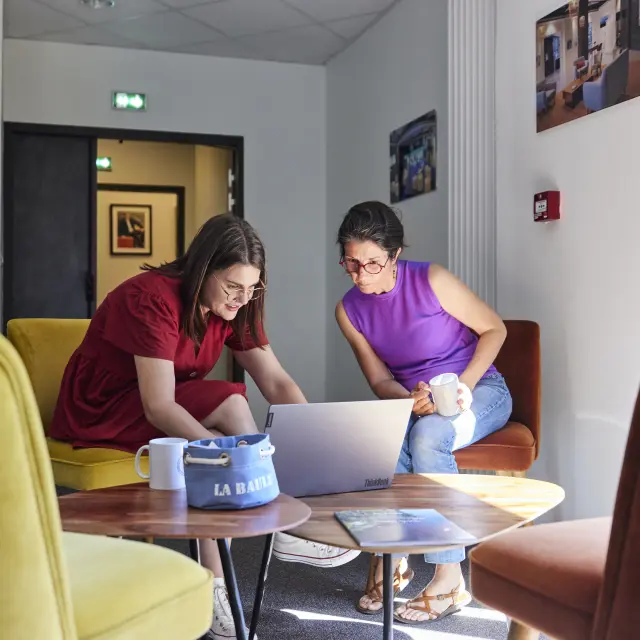 collègues qui échangent devant un ordinateur