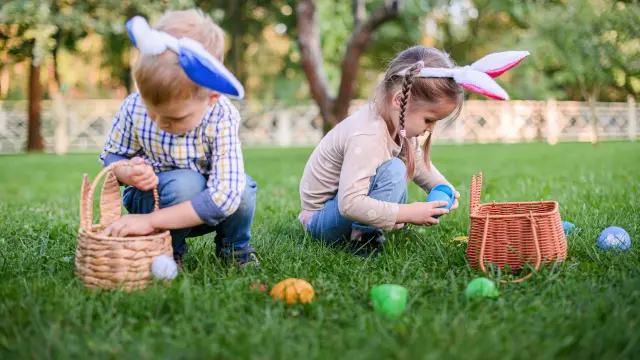 Enfants qui ramassent des œufs de Pâques dans l'herbe