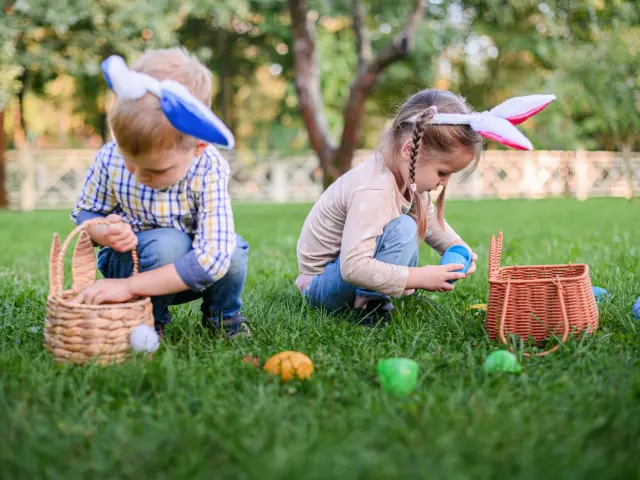 Enfants qui ramassent des œufs de Pâques dans l'herbe