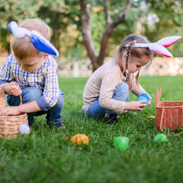 Enfants qui ramassent des œufs de Pâques dans l'herbe