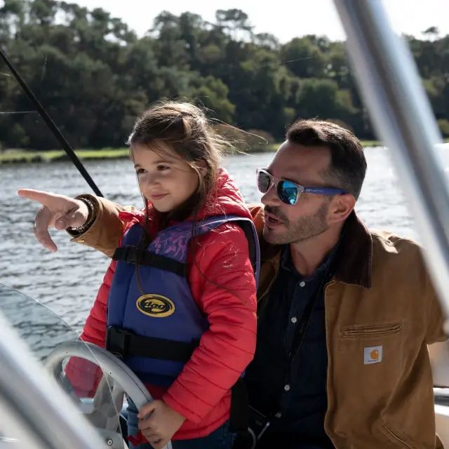 Un père et sa fille qui naviguent à bord d'un bateau électrique sur la Vilaine