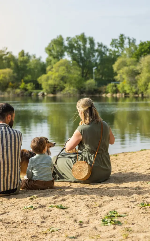Famille assise sur la petite plage de la base de loisirs de Saint-Lyphard